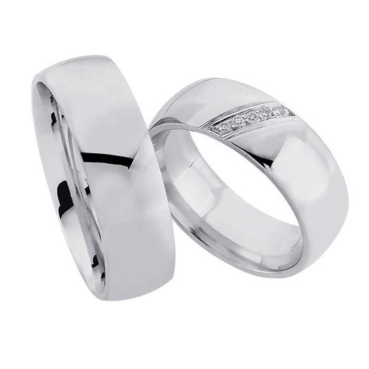 Sofistikerede Nuran vielsesringe i rhodineret sterlingsølv med 0,05 ct diamanter i dameringen – 7 mm brede.